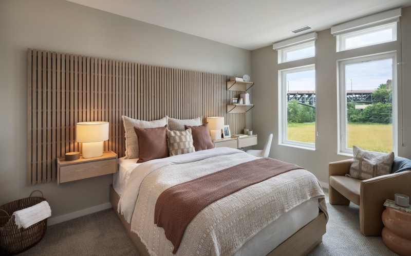 a bedroom with a chair and large window