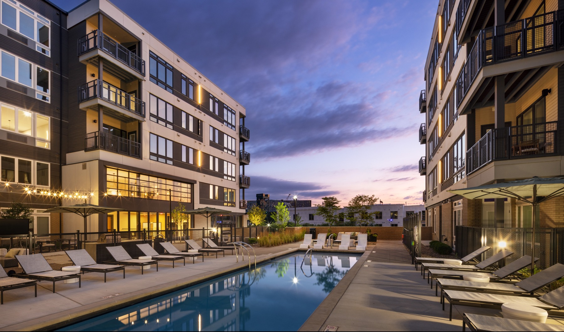 Relax and unwind poolside a swimming pool in a courtyard between buildings