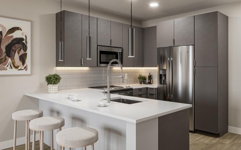 a kitchen with bar stools and a refrigerator